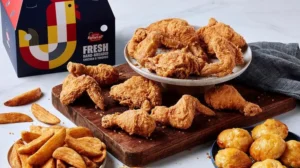 Krispy Krunchy Chicken fried chicken served with potato wedges, biscuits, and a branded takeout box