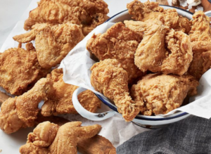 Pieces of crispy fried chicken arranged on plates with a small bowl of dipping sauce